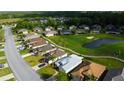 Scenic aerial view of a residential neighborhood featuring lush landscaping, a golf course, and a pond at 10103 Old Tampa Bay Dr, San Antonio, FL 33576