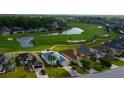 Aerial view of a home on a golf course with a lake and mature trees in a neighborhood at 10103 Old Tampa Bay Dr, San Antonio, FL 33576