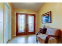 Bright entryway with double doors, neutral walls, ceramic tile flooring, and traditional furnishings at 10103 Old Tampa Bay Dr, San Antonio, FL 33576