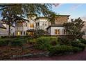 Inviting front yard with mature trees, shrubs, and a brick path leading to the front door at 1058 Roundstone Pl, Palm Harbor, FL 34683