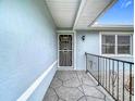 Inviting front porch area with textured concrete and an ornate security door at 12083 Rockford St, Spring Hill, FL 34608