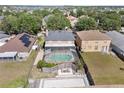 Aerial view of a home showcasing a screened-in pool, fire pit, fenced yard, and surrounding neighborhood at 12215 Adventure Dr, Riverview, FL 33579