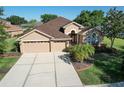 Beautiful home featuring a three-car garage, lush landscaping, and a well-manicured lawn in a peaceful setting at 1408 Brilliant Cut Way, Valrico, FL 33594