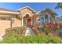 Inviting front entrance with a vibrant red door, manicured bushes, and a walkway leading to the home at 1408 Brilliant Cut Way, Valrico, FL 33594