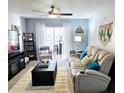 Relaxing living room with a plush sofa, ceiling fan, and sliding glass doors for natural light and fresh air at 1657 Glengarry Dr, Palm Harbor, FL 34684