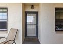 Inviting front door with sidelight windows and a chair outside providing a welcoming entrance to the property at 19029 Us Highway 19 N # 26-204, Clearwater, FL 33764
