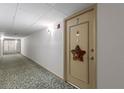 Hallway view leading to Unit 407 adorned with a star decoration on the door at 19029 Us Highway 19 N # 9-407, Clearwater, FL 33764