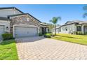 Paver driveway leads to the home's attached garage, complemented by a well-maintained lawn at 19325 Hawk Valley Dr, Tampa, FL 33647