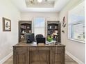 Bright home office features custom shelving, a large desk, and natural light at 19325 Hawk Valley Dr, Tampa, FL 33647