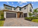 Elegant two-story home with a three-car garage and attractive brick-paved driveway at 19719 Cypress Bridge Dr, Odessa, FL 33556