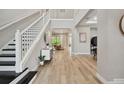 Bright foyer featuring wood floors, high ceilings, and a staircase with black treads at 19719 Cypress Bridge Dr, Odessa, FL 33556