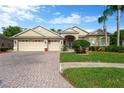 Inviting home featuring a three-car garage and a brick-paved driveway at 20749 Auburn Leaf Trl, Land O Lakes, FL 34638