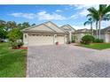 Attractive home with three-car garage, brick-paved driveway, and lush front yard at 20749 Auburn Leaf Trl, Land O Lakes, FL 34638