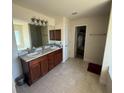 Bathroom featuring double sinks, granite counters, and walk-in closet access at 26357 Trinilas Dr, Punta Gorda, FL 33983