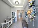 Inviting entryway with a decorative wreath, modern decor, and a glimpse into the spacious interior at 32313 Conchshell Sail St, Wesley Chapel, FL 33545