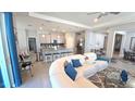 Bright living space featuring open layout, bar stool seating, modern appliances, and view of dining area at 32313 Conchshell Sail St, Wesley Chapel, FL 33545