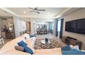 Open-concept living room featuring a sectional sofa, TV, and seamless flow to the dining area at 32313 Conchshell Sail St, Wesley Chapel, FL 33545