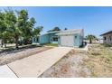 Attractive light blue one-story home showcasing a well-maintained lawn, a driveway, and an attached garage at 4307 Woodfield Ave, Holiday, FL 34691