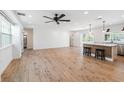 Bright, open-concept living area with hardwood floors, opening to the kitchen with stainless steel appliances and breakfast bar at 4307 Woodfield Ave, Holiday, FL 34691
