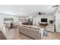 Bright, open-concept living space with hardwood floors and a modern kitchen featuring stainless steel appliances and a breakfast bar at 4307 Woodfield Ave, Holiday, FL 34691