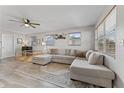 Bright living room featuring a large sectional sofa, ceiling fan, and natural light at 5302 S Himes Ave, Tampa, FL 33611