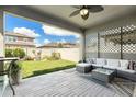 Covered back patio with cozy seating area and a view of the landscaped backyard at 6477 Dutton Dr, Wesley Chapel, FL 33545