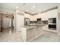 Bright kitchen featuring a large island with a granite countertop and white cabinetry at 6477 Dutton Dr, Wesley Chapel, FL 33545