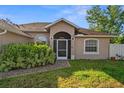 Warm front entrance with brick path leading to arched, screened front door and manicured landscaping at 7288 Castleberry Ter, Englewood, FL 34224