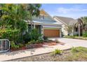 Street view of home highlighting a 2-car garage, palm trees, and verdant landscaping at 7615 S Fitzgerald St, Tampa, FL 33616
