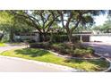 Home with a beautiful lawn, mature trees, and brick driveway leading to the attached garage at 8238 30Th N Ave, St Petersburg, FL 33710