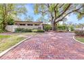 Inviting front yard with a brick walkway leading to the home's entrance, showcasing lush greenery at 8238 30Th N Ave, St Petersburg, FL 33710