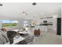Bright open-concept living area flowing into a modern kitchen with stainless steel appliances and backyard views at 8598 Parsons Hill Blvd, Wesley Chapel, FL 33545