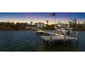 Waterfront home featuring private dock and boat lift with an American flag waving in the background at sunset at 9048 Wharf Ave, Placida, FL 33946