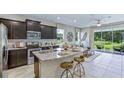 Modern kitchen with stainless steel appliances, granite countertops, dark wood cabinets, and an island with seating at 11393 Velvet Apricot Dr, Land O Lakes, FL 34638