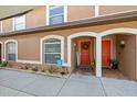 Inviting townhouse entrance featuring colorful doors, arched entryways, and neat landscaping at 14910 Par Club Cir, Tampa, FL 33618
