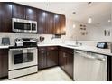 Modern kitchen features stainless steel appliances, white countertops, and dark cabinets at 14910 Par Club Cir, Tampa, FL 33618