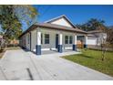 Stylish renovated home with a long driveway and manicured lawn, showcasing modern curb appeal at 1808 E Comanche Ave, Tampa, FL 33610