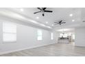 Spacious living room with light gray flooring, recessed lighting, and a view into the modern kitchen at 1808 E Comanche Ave, Tampa, FL 33610