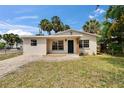 Charming home featuring a well-manicured lawn, brick walkway, neutral paint, and mature landscaping at 1923 W State St, Tampa, FL 33606