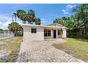 Charming home featuring a well-manicured lawn, brick walkway, neutral paint, and mature landscaping at 1923 W State St, Tampa, FL 33606