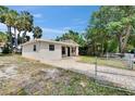 Charming home featuring a well-manicured lawn, brick walkway, neutral paint, and mature landscaping at 1923 W State St, Tampa, FL 33606