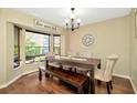 Bright dining room featuring modern chandelier, rustic dining table and bench seating by the large window at 1939 Sandalwood Pl, Clearwater, FL 33760
