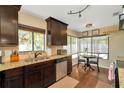 Inviting kitchen features granite countertops, dark wood cabinets, stainless steel appliances, and a sunny breakfast nook at 1939 Sandalwood Pl, Clearwater, FL 33760