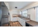 Bright kitchen with granite countertops, white cabinetry, and modern stainless steel appliances at 2030 Magnolia Dr, Clearwater, FL 33764