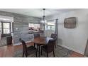 Charming dining room with a round table, four chairs, stylish light fixture, and wood accent wall at 2213 Hammock Pine Blvd, Clearwater, FL 33761