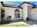 Close up of a well-kept front entrance featuring an arched window and tasteful landscaping at 2347 Foggy Ridge Pkwy, Land O Lakes, FL 34639