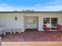 Inviting front porch features brick pavers, a covered entrance, and outdoor seating at 2673 Clubhouse S Dr, Clearwater, FL 33761