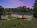 Aerial view of house backyard featuring a fire pit, storage shed, and covered porch at 34477 Poinsettia Pl, Dade City, FL 33523