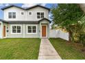Charming two-story home with green grass, walkway and tidy landscaping on a sunny day at 3455 17Th S Ave, St Petersburg, FL 33711