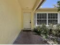 Inviting front porch featuring a white door, neutral paint and meticulous landscaping at 3647 Lake St George Dr, Palm Harbor, FL 34684